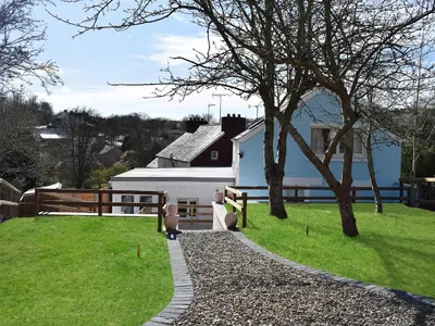 a house with a grassy yard next to a building at Delfryn in Llanarth