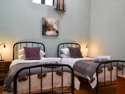 two beds sitting next to each other in a bedroom at Maes Merlin in Llanddeusant