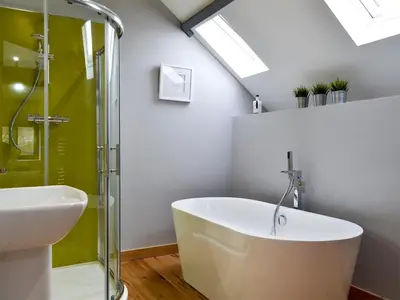 a bathroom with a bath tub and a sink at Maes Merlin in Llanddeusant