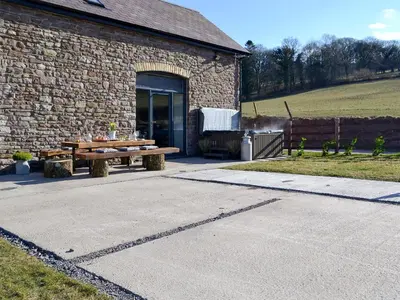 a brick building with a picnic table in front of it at Maes Merlin in Llanddeusant