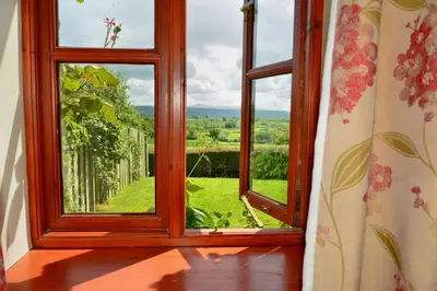a window with a view of a green field at Upper Onibury Cottages in Onibury