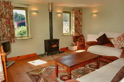 a living room with a wood stove in it at Upper Onibury Cottages in Onibury