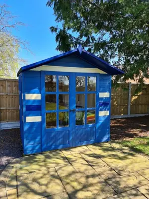 a blue shed with windows in a yard at Ruth's Repose Country Retreat with private hot tub & Stunning Views in Shrewsbury