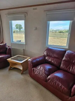 a living room with a leather couch and a coffee table at Ruth's Repose Country Retreat with private hot tub & Stunning Views in Shrewsbury