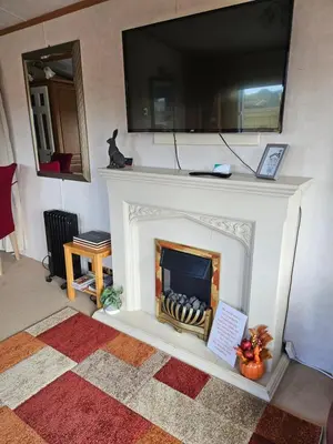 a living room with a fireplace with a television above it at Ruth's Repose Country Retreat with private hot tub & Stunning Views in Shrewsbury
