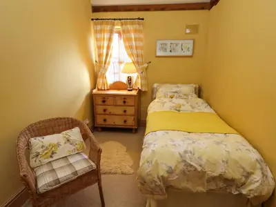 a bedroom with a bed and a chair and a window at The Old Dairy in Shrewsbury