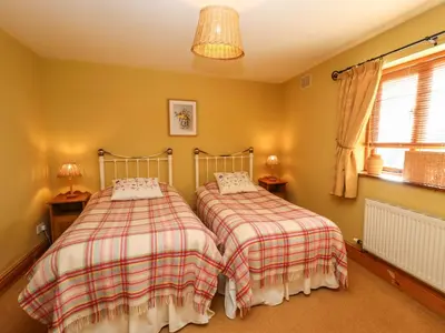 two beds in a bedroom with yellow walls at The Granary in Shrewsbury