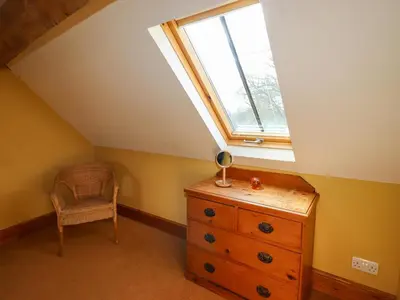a attic room with a dresser and a window at The Granary in Shrewsbury