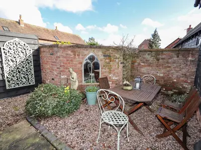 a patio with a table and chairs in a yard at The Granary in Shrewsbury