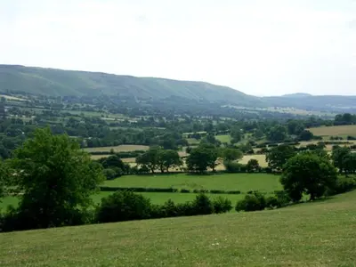 a view of a green field with trees on a hill at The Byre in Bishops Castle
