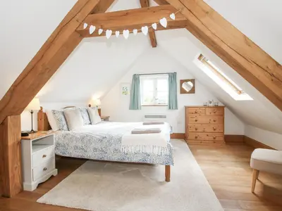 a attic bedroom with a bed and a window at The Old Workshop in Church Pulverbatch