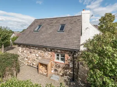 an old stone cottage with a window and a roof at The Old Workshop in Church Pulverbatch