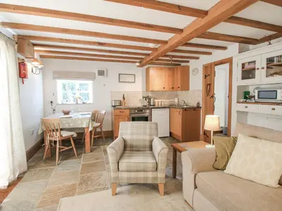 a kitchen and living room with a table and chairs at The Old Workshop in Church Pulverbatch