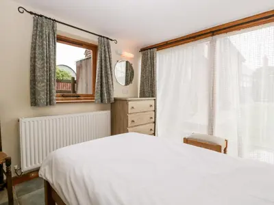 a bedroom with a white bed and a window at Stable End in Pembridge
