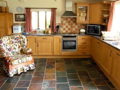 a kitchen with a couch and a chair in a kitchen at The Coach House in Shrewsbury
