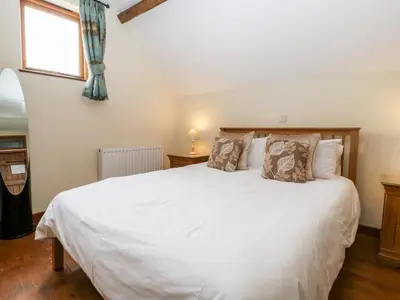 a bedroom with a large white bed with a window at The Hop Kiln in Pembridge