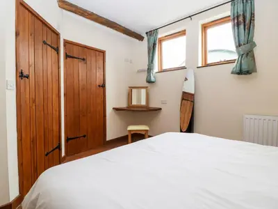 a bedroom with a bed and a wooden door at The Hop Kiln in Pembridge