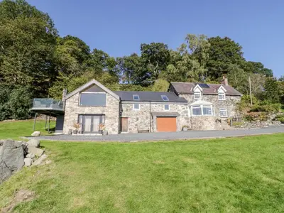 a large stone house with a driveway at Tyn Llwyn in Gwyddelwern