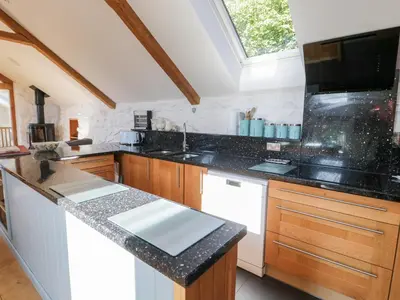 a kitchen with black counter tops and a window at Tyn Llwyn in Gwyddelwern