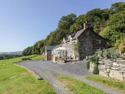an old stone house on a gravel road at Tyn Llwyn in Gwyddelwern