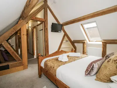 a bedroom with a bed and a tv on the wall at The Milking Parlour in Craven Arms