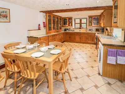 a large kitchen with a wooden table and chairs at The Stable in Craven Arms