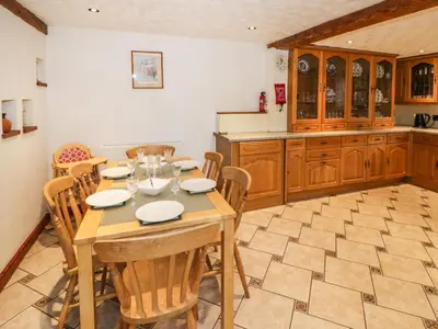 a kitchen with a table and chairs in a room at The Stable in Craven Arms