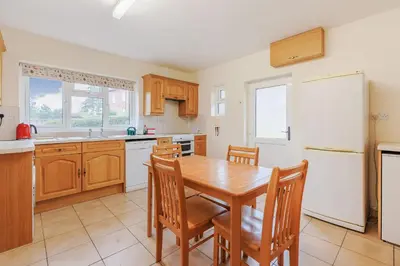 a kitchen with a table and chairs and a refrigerator at Meadow Lea in Leominster