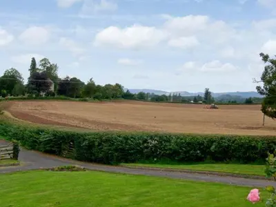 a large field with a dirt field in the distance at The Old Cider Mill in Farden