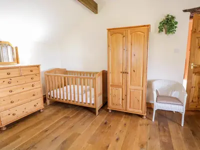 a nursery with two cribs and a dresser at Tyddyn in Dyffryn