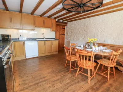 a kitchen with a table and chairs and a kitchen with a ceiling at The Farmhouse in Ciliau-Aeron