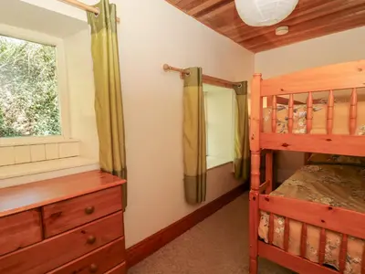 a bedroom with a bunk bed next to a window at The Farmhouse in Ciliau-Aeron