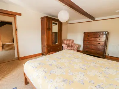 a bedroom with a bed and a dresser at The Farmhouse in Ciliau-Aeron