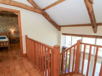 a hallway with wooden floors and a staircase with windows at Mill Cottage in Ciliau-Aeron