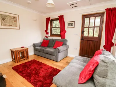 a living room with a couch and a chair at Penlon in Aberystwyth