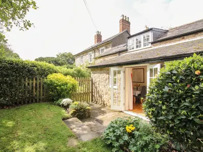 a house with a fence and a yard at The Coach House in Ludlow