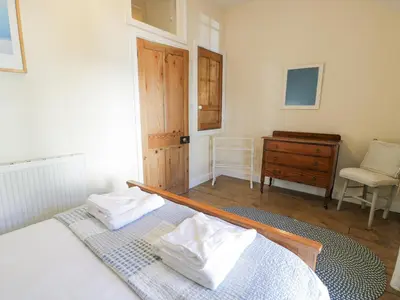 a bedroom with a bed and a desk and a chair at Ty Gwyn in Aberdyfi