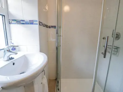 a bathroom with a sink and a shower at Ty Gwyn in Aberdyfi