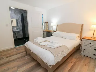 a bedroom with a bed with towels on it at Cariad Cottage in Cilcennin