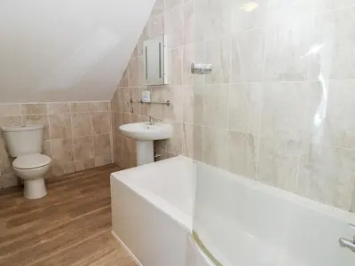 a bathroom with a tub and a toilet and a sink at Cariad Cottage in Cilcennin