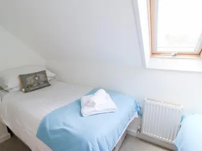 a bedroom with two twin beds and a window at Cariad Cottage in Cilcennin