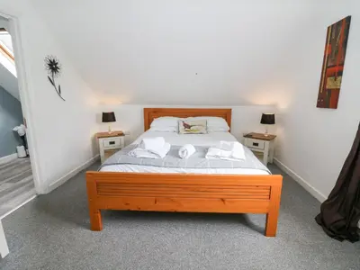 a bedroom with a wooden bed with two night stands at Cariad Cottage in Cilcennin