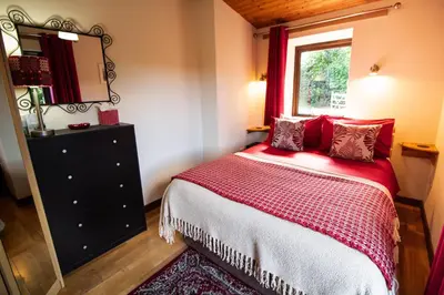 a bedroom with a bed and a window and a mirror at Sycamore Lodge in Rhayader