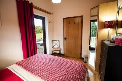 a bedroom with a red bed and a window at Sycamore Lodge in Rhayader