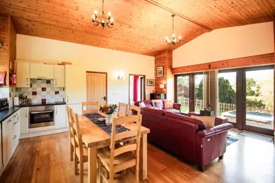 a kitchen and living room with a couch and a table at Sycamore Lodge in Rhayader