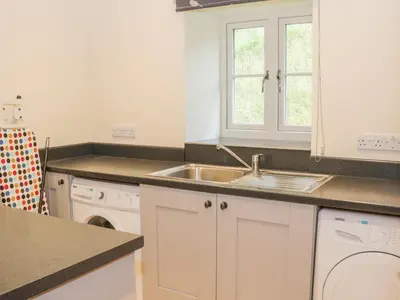 a kitchen with a sink and a dishwasher at The Old Mill in Llanfihangel Rhydithon