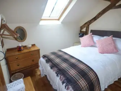 a bedroom with a bed and a dresser with a window at The Old Mill in Llanfihangel Rhydithon