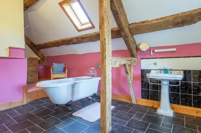 a bathroom with a white tub and a sink at Maesgwyn in Felindre