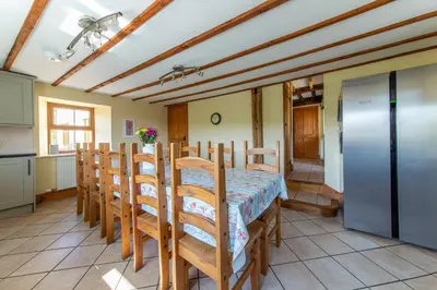 a kitchen and dining room with a table and chairs at Maesgwyn in Felindre