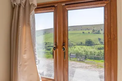 a sliding glass door with a view of a field at Maesgwyn in Felindre